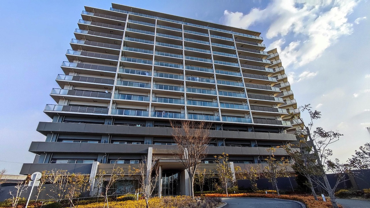 プレミアムフォート稲沢の外観。稲沢市下津北山に立つ14階建ての大規模マンションで、低層部にエントランスと植栽が整備されている。稲沢駅から徒歩9分の立地。