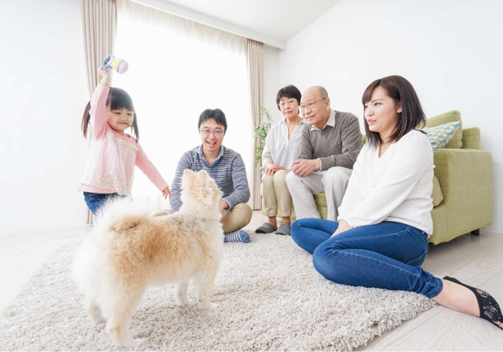 親子三世代とペットのわんちゃんがリビングで集まっている写真 (1)