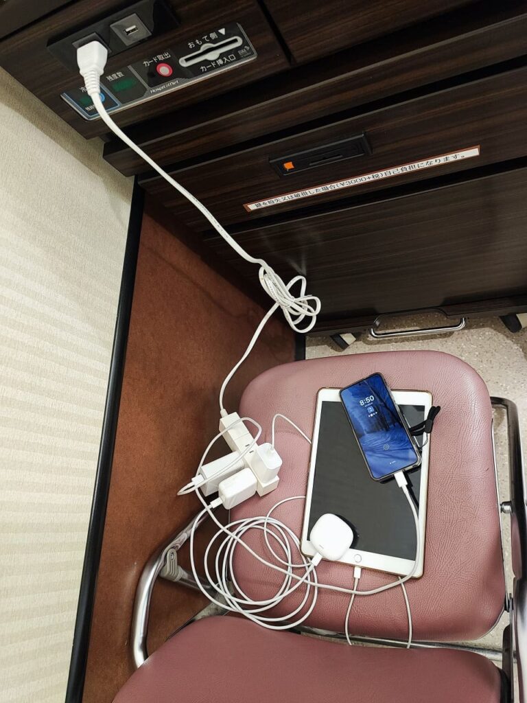 延長コードをパイプ椅子の上に置いてスマホを充電