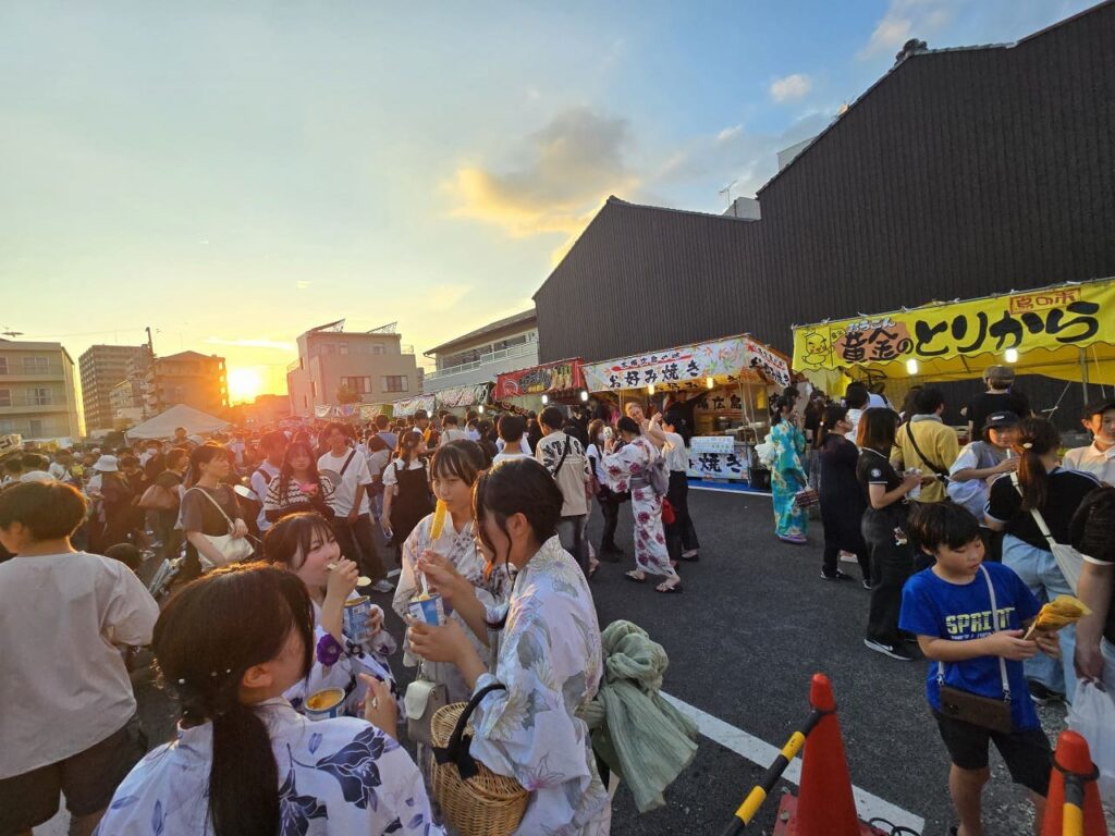一宮七夕まつり真清田神社近くの屋台広場-浴衣姿の来場者と夕焼けで賑わう夜店街