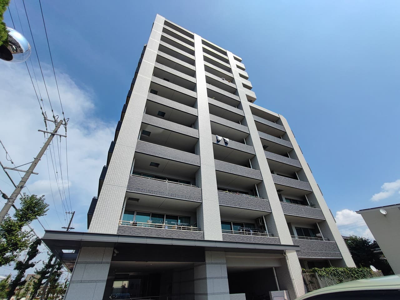 青空にそびえ立つシンメトリーな外観が美しい「ロフティ稲沢駅前」。 白とグレーを基調にした洗練されたデザインで、モダンな雰囲気を放っています。 バルコニーが整然と並ぶファサードは高層マンションならではの存在感を示し、開放的な暮らしをイメージさせます。 駅近でありながら落ち着いた住宅街に位置し、利便性と静かな住環境を兼ね備えた安心の住まいです。