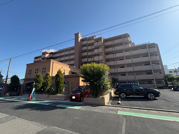 シャトレ愛松稲沢Ⅷの外観写真。ブラウン系の外壁と整った植栽が特徴の落ち着いたマンションで、敷地内には駐車場も完備されています。