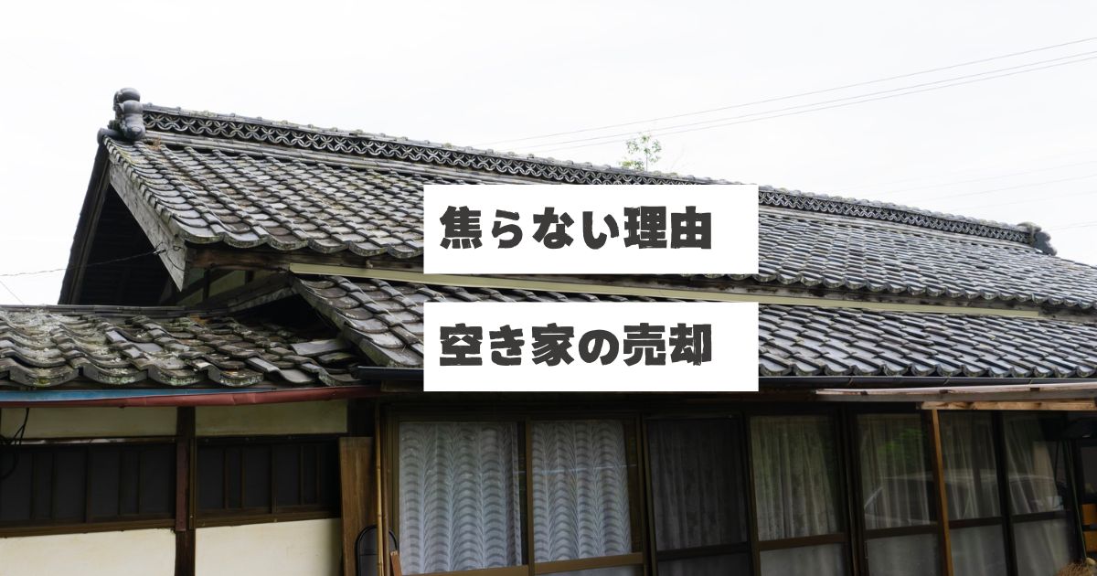 古い日本家屋の瓦屋根とレースカーテンがかかった窓が見える空き家の外観。画像には「焦らない理由 空き家の売却」というテキストが重ねられている。空き家の売却を焦らず、買手を募る前に建物解体と測量を先行して進める理由を説明する稲沢あんしん不動産の記事アイキャッチ画像。アスベスト、地中埋設物、面積不足など、進めていく中で出てくるかもしれない問題発生のリスクを事前に潰すことで売主を守る考え方を表現している。相続した実家や家じまいでの売却準備の重要性を伝える内容。