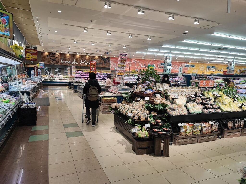 ニッケタウン稲沢の平和堂フーズマーケット店内の様子。Fresh Meat(鮮肉コーナー)やDaily Foodのサインが見える明るい売り場。野菜コーナーには新鮮な白菜や葉物野菜が陳列され、買い物客がショッピングカートを押して買い物をしている