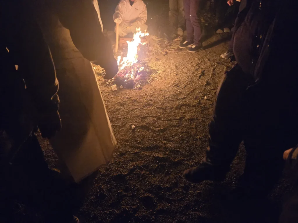 国府宮はだか祭・夜儺追神事。焚き火の周囲の地面に、参拝者が神男めがけて投げた正方形の白い紙の礫（つぶて）が散らばっている。この礫には厄が移っているとされ、踏んではいけない。