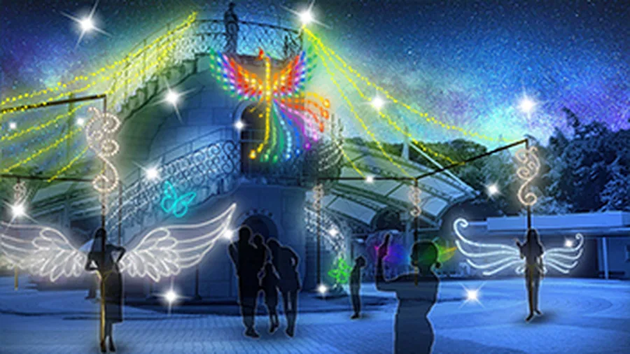 夜の138タワーパークで行われるイルミネーションイベントの様子。白い螺旋階段状のオブジェの上に、フェニックス(不死鳥)を模した虹色に光るイルミネーションが浮かび上がっている。手前には白い翼の形をしたライトオブジェが左右に配置され、来園者のシルエットが小さく写っている。