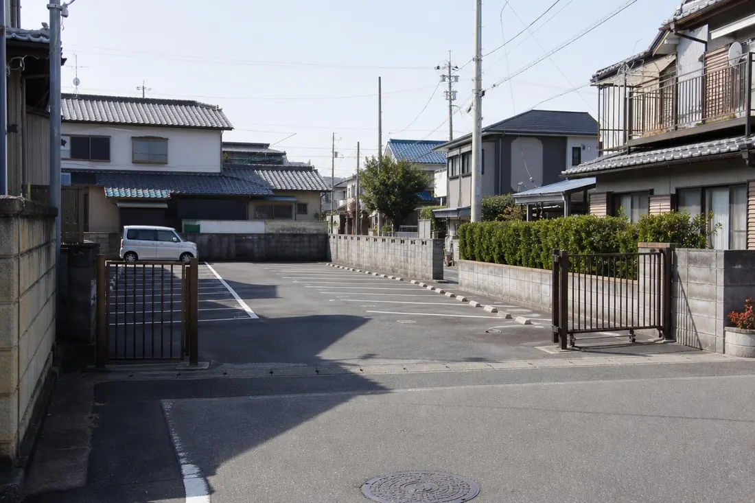 稲沢市近郊の住宅街にある月極駐車場の実写風景。相続で受け継いだ駐車場を売るか残すか迷う方に向けて、地域に根ざした相談先があることを伝える一枚。