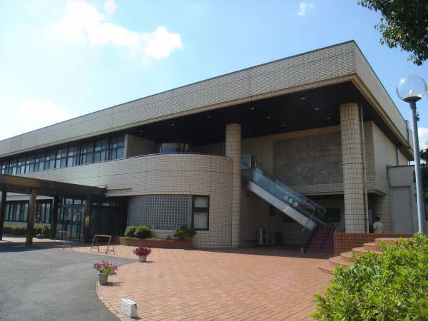稲沢市立平和町図書館が入る稲沢市平和支所の建物外観。白とベージュを基調とした2階建ての公共施設で、前面に駐車場が広がる。