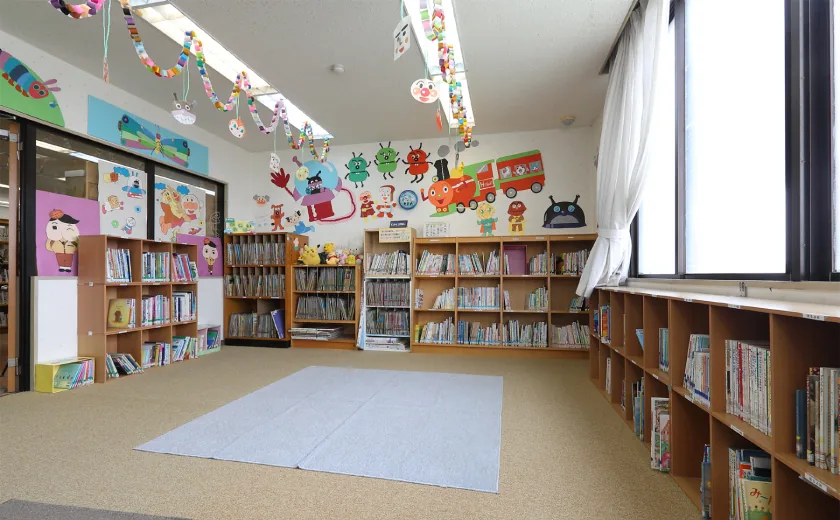 平和町図書館の「おはなしの部屋」。カーペット敷きの小上がりに絵本が並び、親子で靴を脱いでくつろぎながら読み聞かせができるスペース。