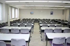 祖父江の森図書館2階の学習室。長机と椅子が整然と並び、窓から自然光が入る明るい学習スペース。