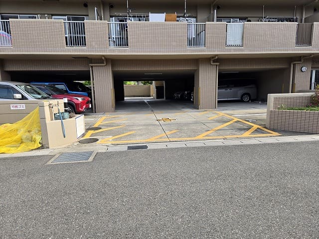 藤和シティコープ国府宮Ⅱの駐車場入口。1階部分がピロティ式になっており、車が停められている様子。